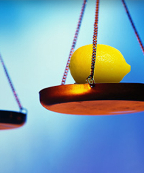 A lemon placed on one side of a balance scale.